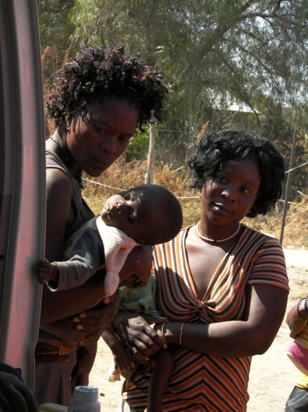 Two mothers with their children watch immunisations and wait their turn, Kunene Namibia National Immunisation Days 2011 Round One